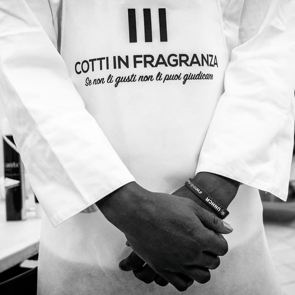 Mains croisées sur un tablier Cotti in Fragranza, dans l'atelier de Palerme